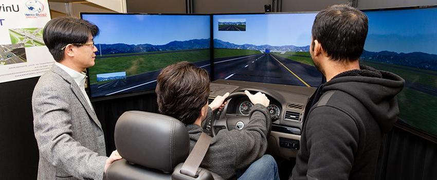 土木工程 students using the driving simulator with professor.